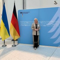 Перший заступник Начальника ОВА Наталя Заболотна стоїть біля Прапора України та прапора Німеччини