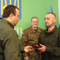Начальник ОВА Сергій Борзов вручає нагороду військовому