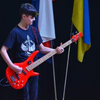 юнак з гітарою на сцені