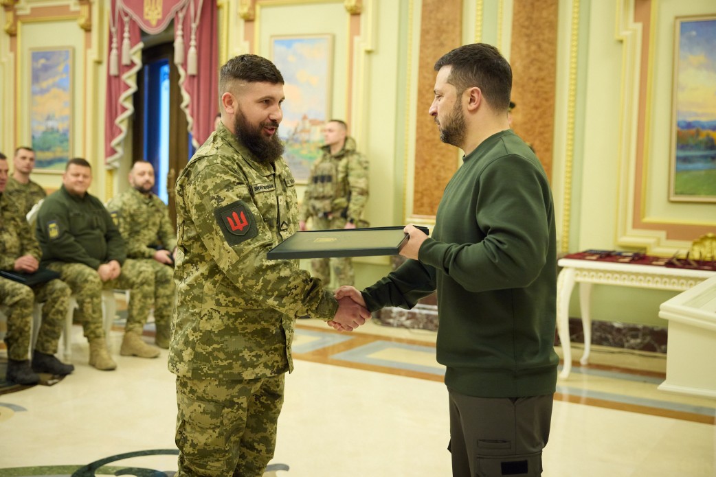 Президент України Володимир Зеленський вручає нагороду військовому