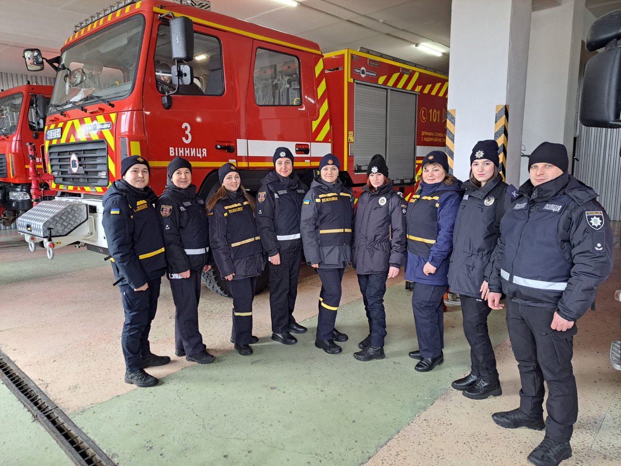 на фото психологи ДСНС та Поліції Вінниччини стоять біля пожежної машини