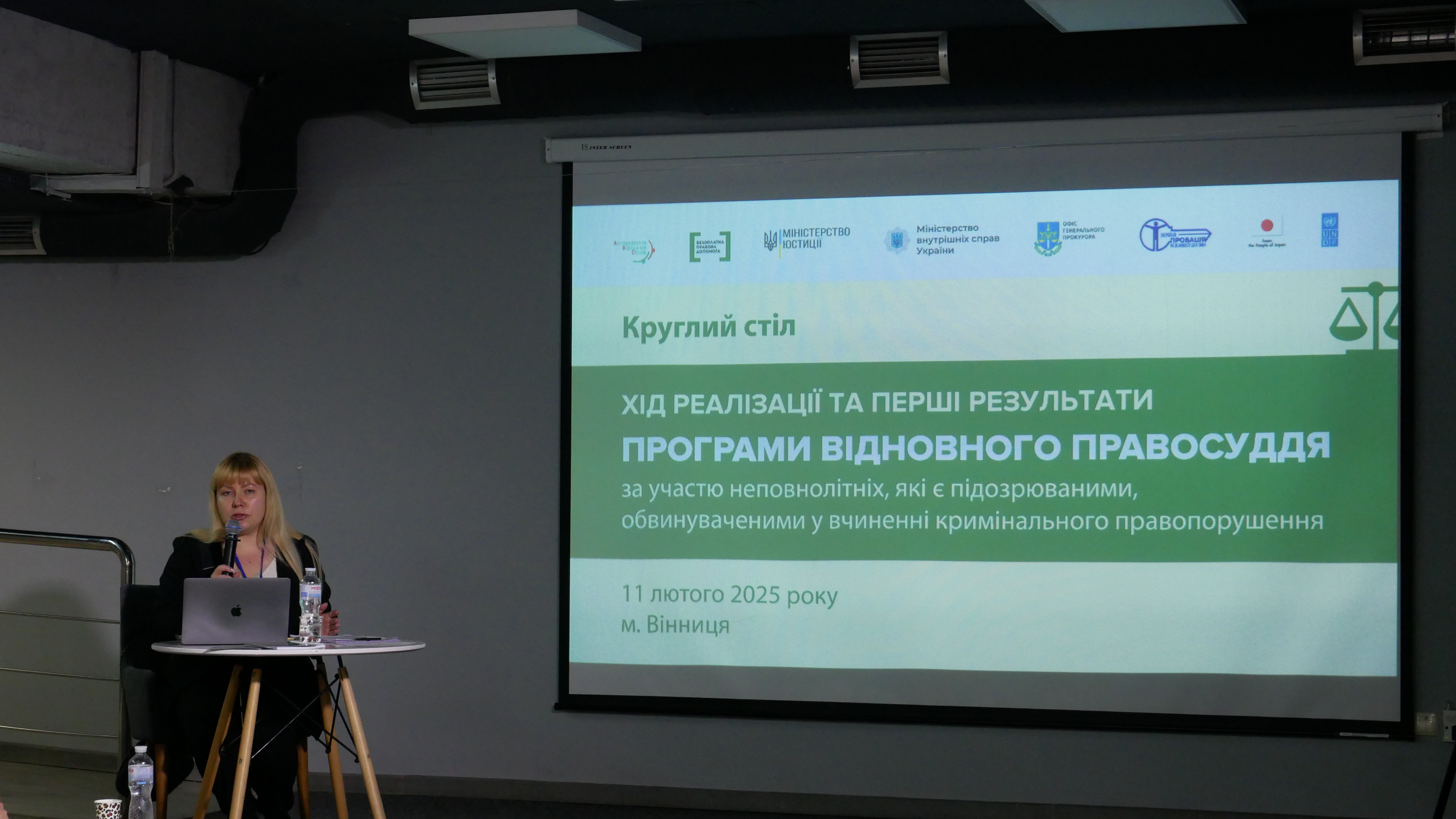 Модераторка круглого столу на тему «Хід реалізації та перші результати Програми відновного правосуддя за участю неповнолітніх, які є підозрюваними, обвинуваченими у вчиненні кримінального правопорушення» та основний слайд презентації 