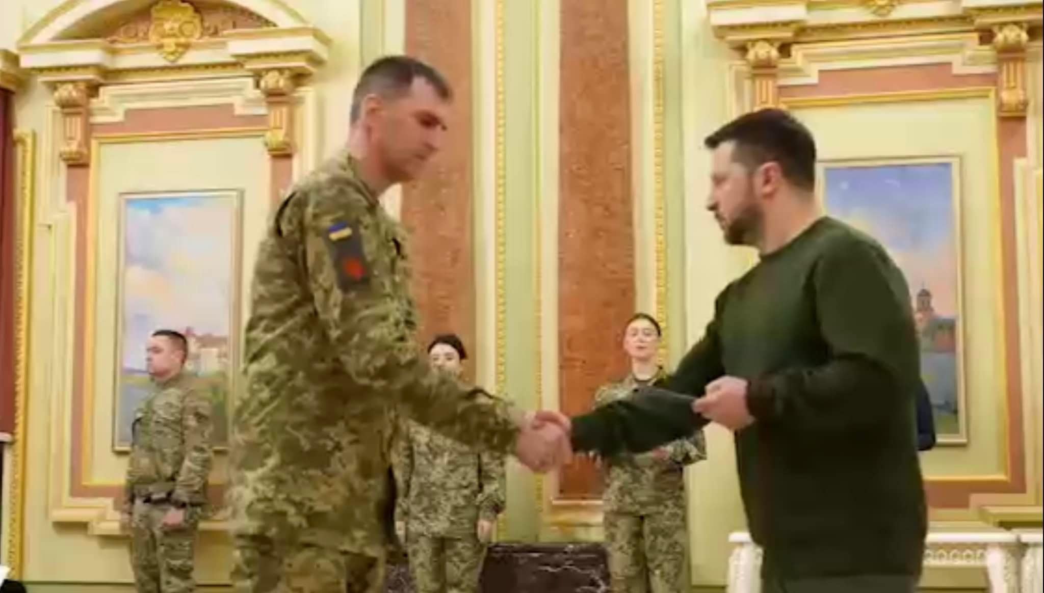 Президент України Володимир Зеленський вручає сертифікат на квартиру захиснику