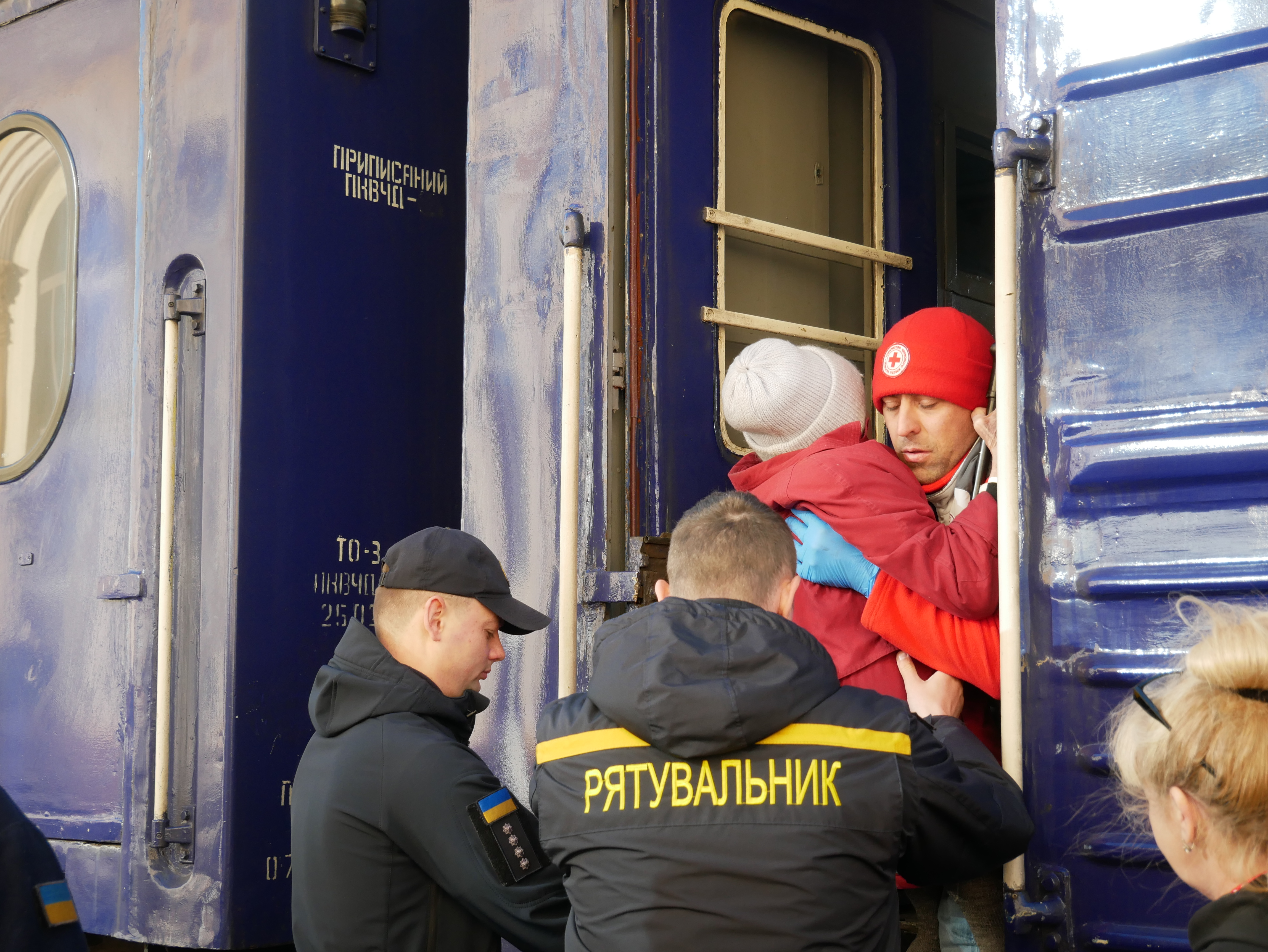 Рятувальники виносять з потягу евакуйовану жінку