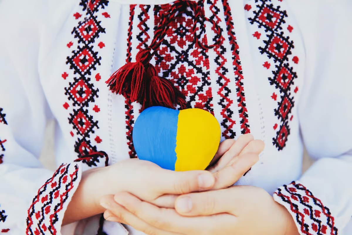 вишиванка та фігурка синьо-жовтого серця у долоньках
