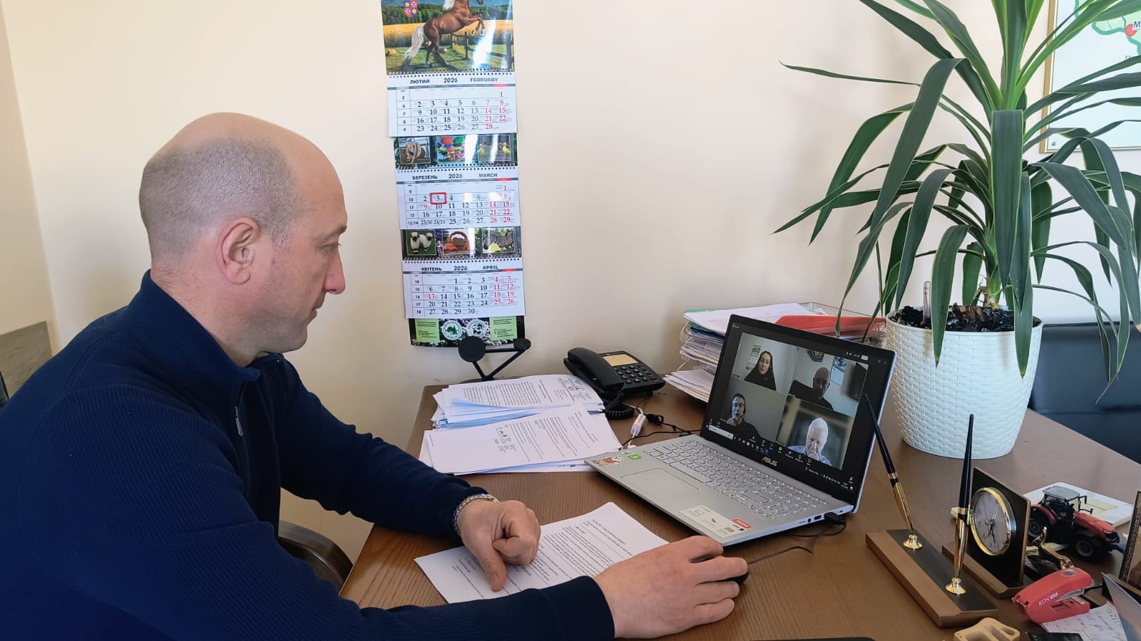 Директор депртаменту сидить в кабінеті за робочим столом перед ними монітор комп'ютера