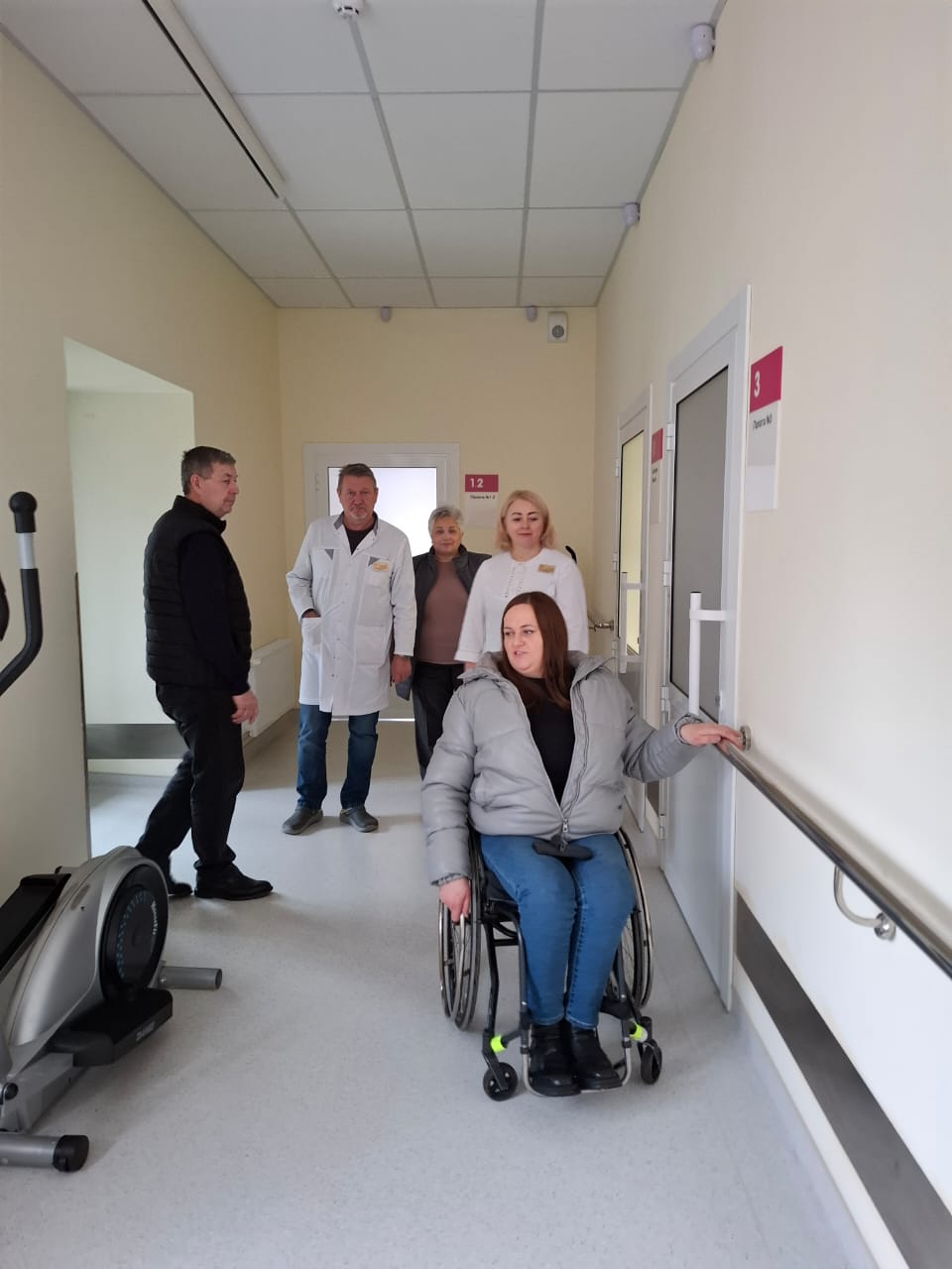 Дівчина в кріслі колісному оглядає приміщення