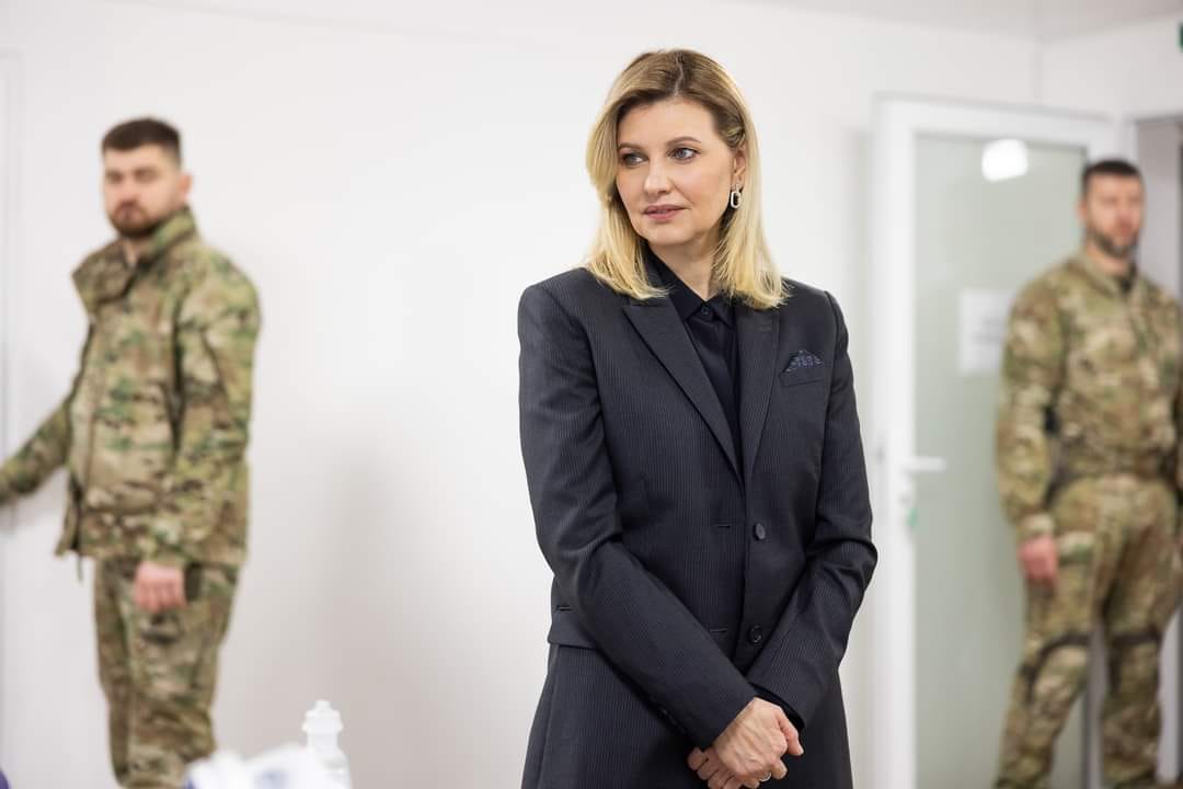 Жінка стоїть попереду двох військових