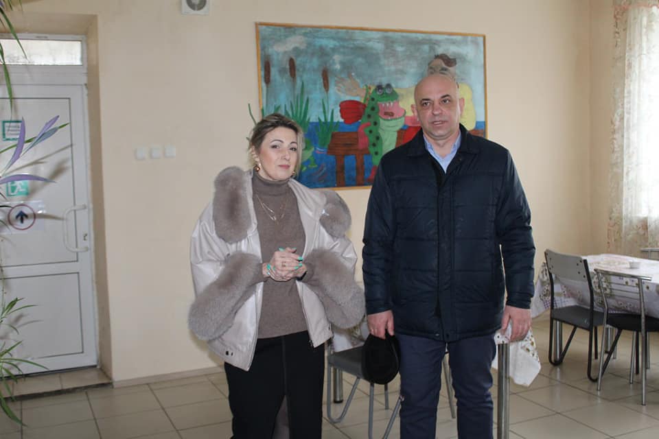 Чоловік і жінка стоять у кімнаті з картинами.