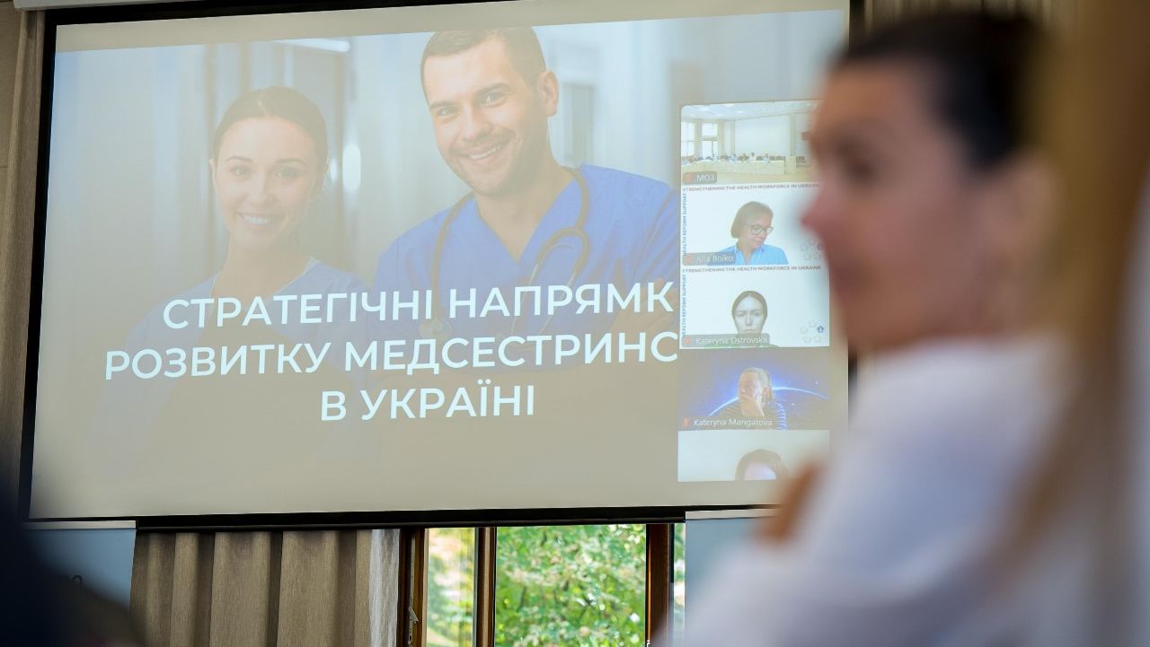 Жінка виступає з презентацією перед групою людей.