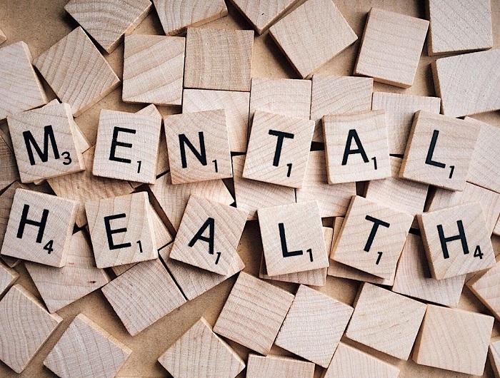 Дерев'яними квадратними фішками з літерами викладена фраза "ментальне здоров'я" англіською мовою