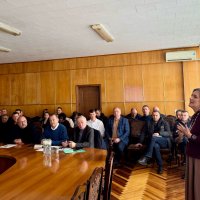 Учасники наради-семінару  сидят в залі, очільниця асоціаці свинарів України виступає