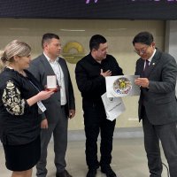 Заступник Начальника ОВА з питань цифрового розвитку, цифрових трансформацій і цифровізації (CDTO) Андрій Кавунець та ректор Вінницького національного медичного університету імені Микола Пирогова Вікторія Петрушенко вручають подарунок з України корейському колезі