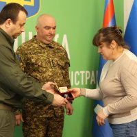 Начальник ОВА Сергій Борзов вручає нагороду родині захисника