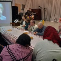 Люди сидять за столом і дивляться відео