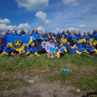 Звільнені з російського полону люди з прапорами України