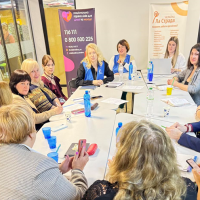 Учасники заходу сидять за круглим столом в аудиторії