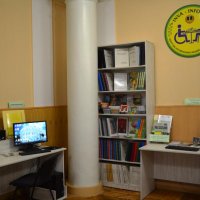 Зала бібліотеки. Два столи з комп'ютерами та книжкові полиці
