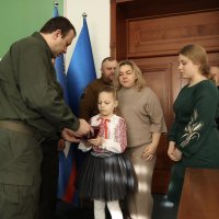 Начальник ОВА Сергій Борзов вручає нагороду родині захисника