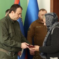 Начальник ОВА Сергій Борзов вручає нагороду родині захисника