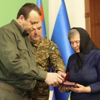 Начальник ОВА Сергій Борзов вручає нагороду родині захисника
