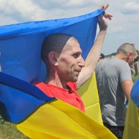 Звільнений з російського полону чоловік з прапором України
