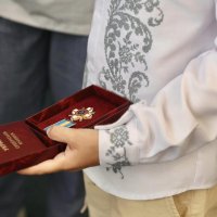 Хлопчик у вишитій сорочці тримає у руці нагороду