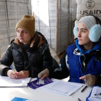 Працівниці Міжнародної організації з міграції, які видають гуманітарну допомогу