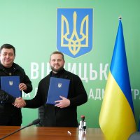 Заступник Начальника ОВА Андрій Кавунець та директор БО «БФ «Карітас Вінниця» Василь Комарницький тримають в руках Меморандум