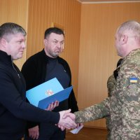 заступник Начальника ОВА Олександр Піщик, директор Департаменту оборонної роботи та забезпечення правопорядку Костянтин Меньшіков та військовий під час нагородження