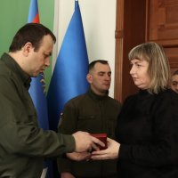 Начальник ОВА Сергій Борзов вручає нагороду родині захисника