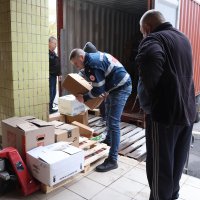 Чоловіки розвантажують коробки гуманітарного вантажу