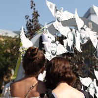 Дівчата вшановують пам’ять загиблих біля Меморіалу пам'яті жертв російського обстрілу міста 14 липня 2022 року
