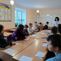 Фото з заходів. Люди в аудиторії сидять за столами