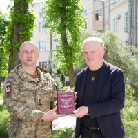 Заступник начальника ОВА Сергій Здітовецький та військовий тримають табличку 95-ї окремої десантно-штурмувої бригади