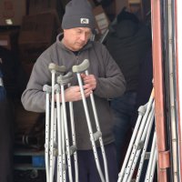 Чоловік тримає в руках милиці